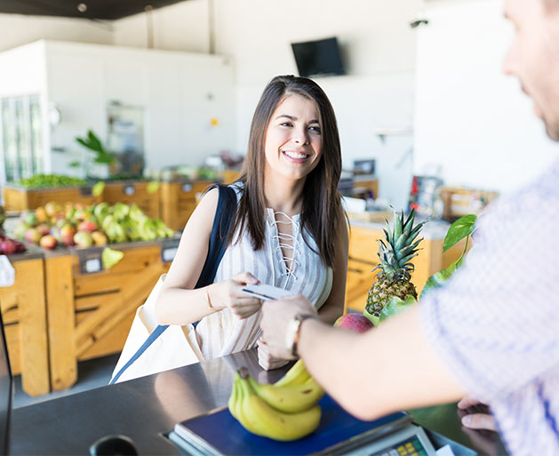 A woman paying for fresh bananas 